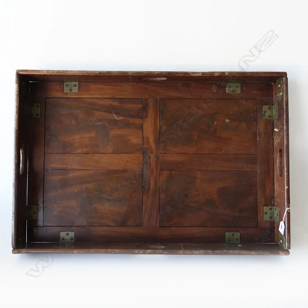 A 19thC teak campaign butler's tray table- the two-handled folding top with brass hinges supported on folding X-framed base. 770 x 510mm Image 1++