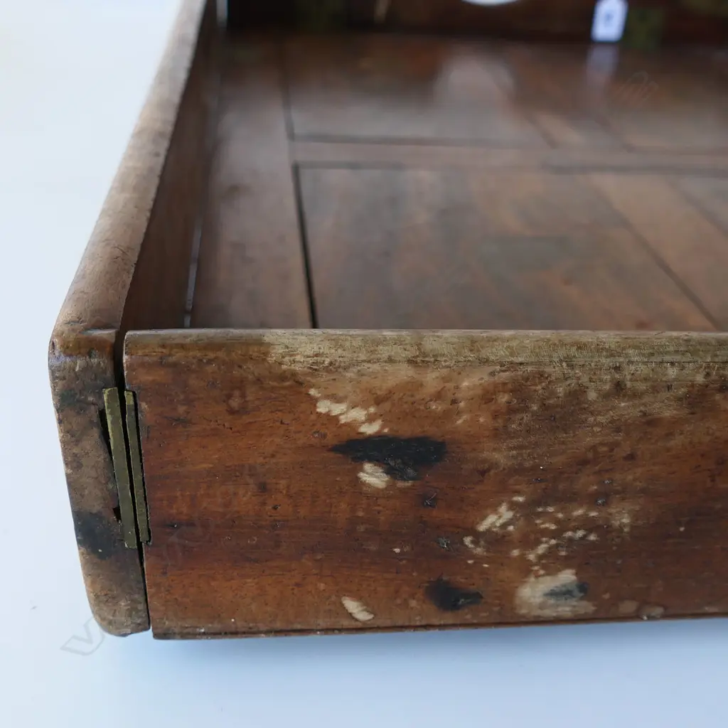 A 19thC teak campaign butler's tray table- the two-handled folding top with brass hinges supported on folding X-framed base. 770 x 510mm Image 1++