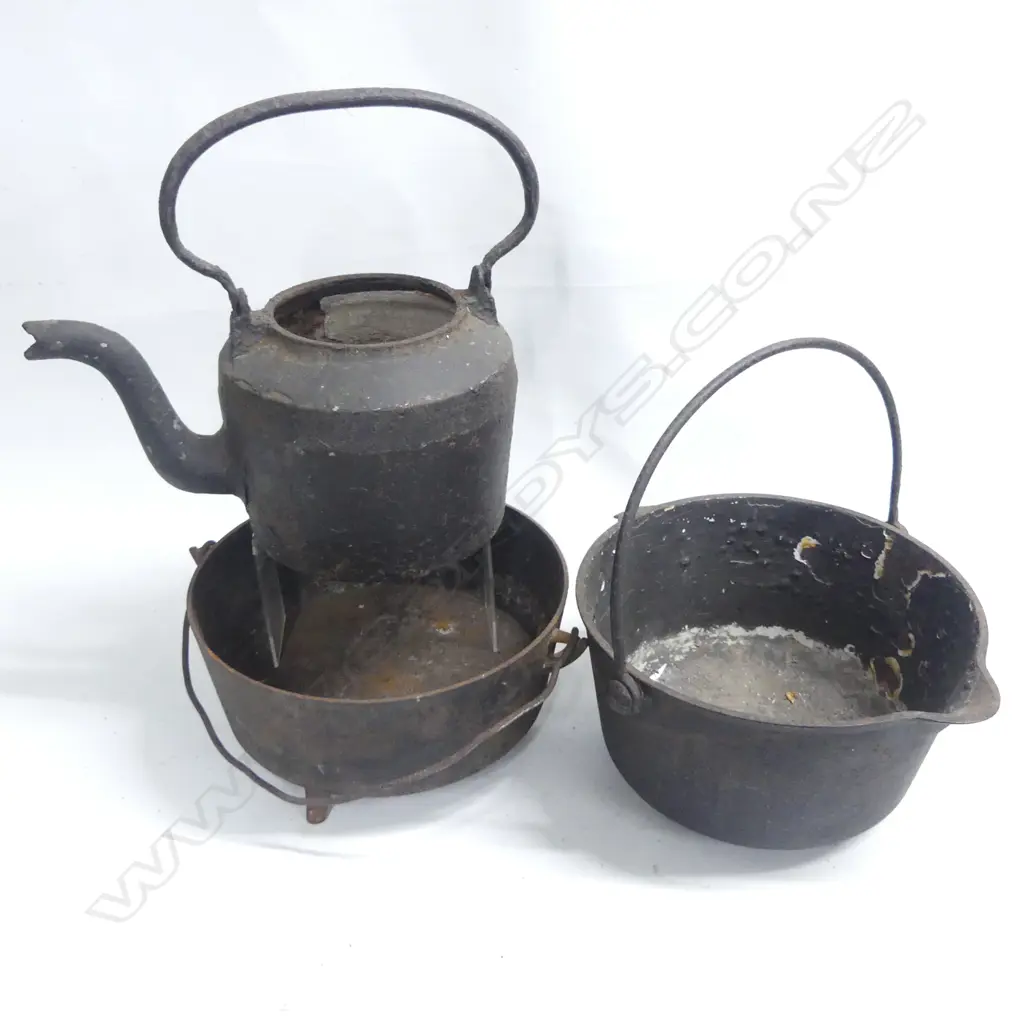 Two cast iron camp ovens and a kettle, lacking lids, one raised on three legs, Image 1++