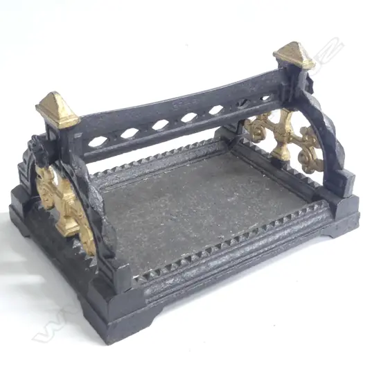 A Victorian blackened iron boot scraper with gold painted decoration. W.380mm