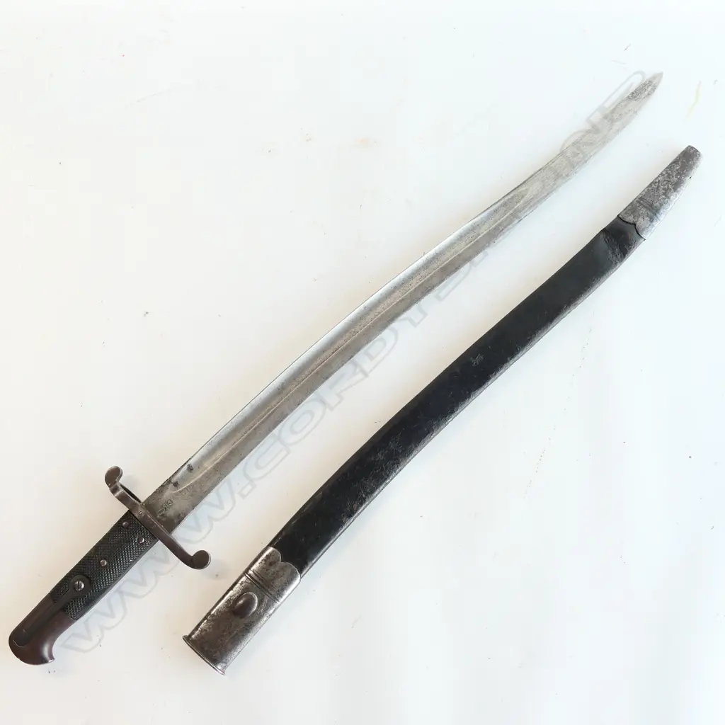 British P.1856/58 Sword Bayonet. Good leather grips. Bar on barrel fitting. Cross guard numbered ‘01258’. Yataghan blade edge with some old file marks and a small amount of old pitting at the tip. Leather scabbard with old dent by chape and chape tip holed Image 1++