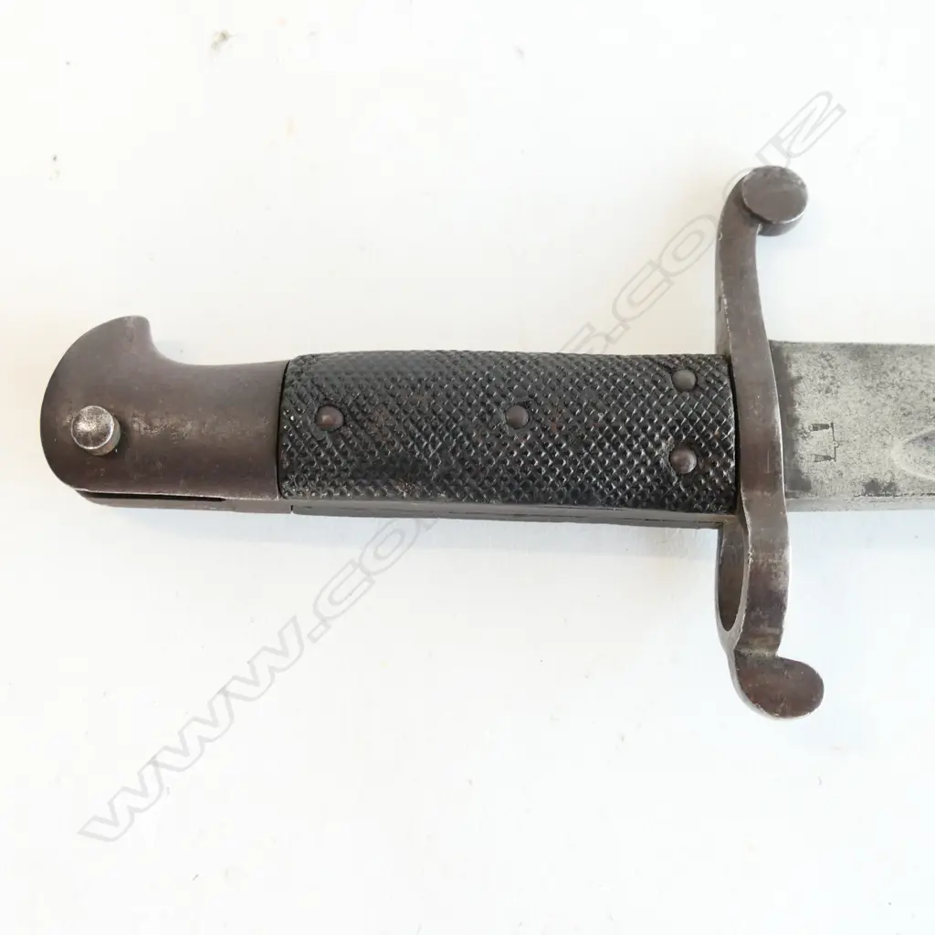 British P.1856/58 Sword Bayonet. Good leather grips. Bar on barrel fitting. Cross guard numbered ‘01258’. Yataghan blade edge with some old file marks and a small amount of old pitting at the tip. Leather scabbard with old dent by chape and chape tip holed Image 1++