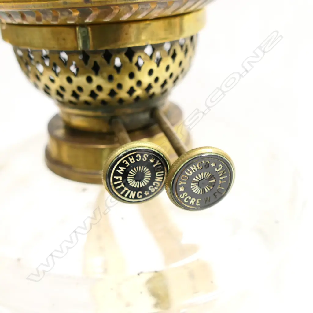 A Victorian kerosene lamp with etched cranberry glass shade. The black china base and brass stand supporting a plain glass oil reservoir with two bands of cut decoration, H.540mmm Image 1++