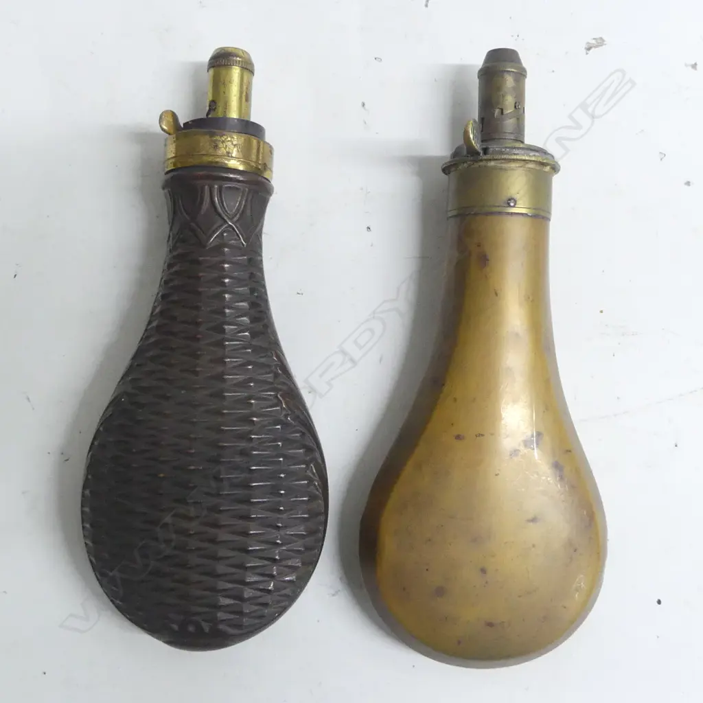 Two Victorian copper and brass powder flasks with graduated dispenser nozzles one of plain bag shape with nozzle to dispense 2 to 2¾ drams, the other decorated with basket weave, the nozzle marked Dixon & Sons, Made in England. Image 1++