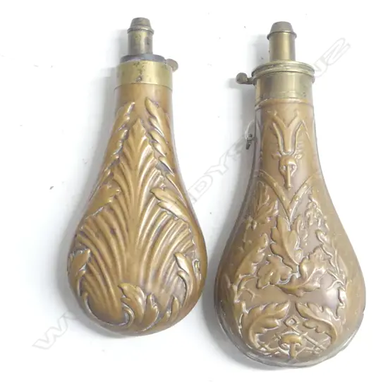 Two Victorian copper powder flasks, with graduated dispenser nozzles one decorated with oak leaves and game the other with acanthus leaves.