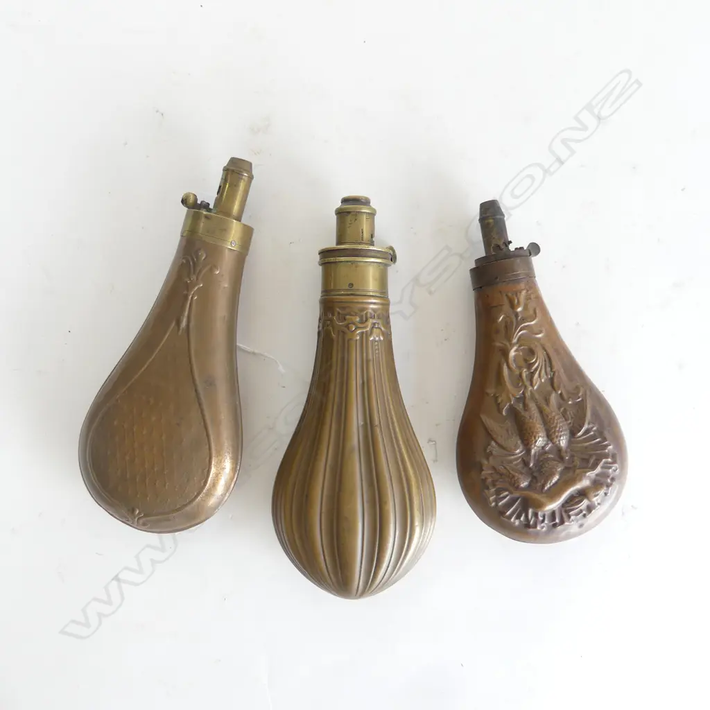 Three Victorian gunpowder flasks, with decoratively moulded bag shaped bodies. Image 1++