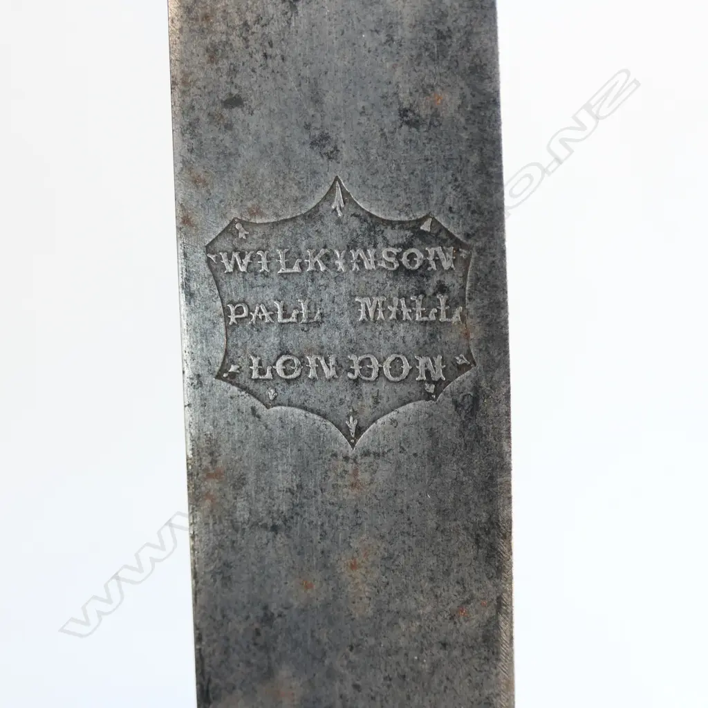 An 1845 Pattern Navy Cutlass. 740mm long, single edged blade with spear point. Makers logo inside shield ‘Wilkinson, Pall Mall, London’. Image 1++