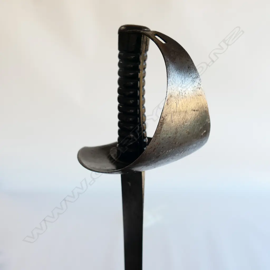 An 1845 Pattern Navy Cutlass. 740mm long, single edged blade with spear point. Makers logo inside shield ‘Wilkinson, Pall Mall, London’. Image 1++