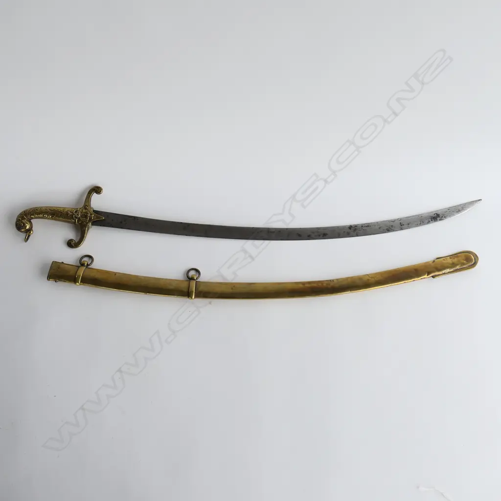 British Mamaluke-stle Army Band sword, with cast brass grip, recurved crossguard with langets, pommel with foliate raised decoration, and ring for sword knot. 710mm curved, single edged blade with scattered light to moderate pitting. Image 1++