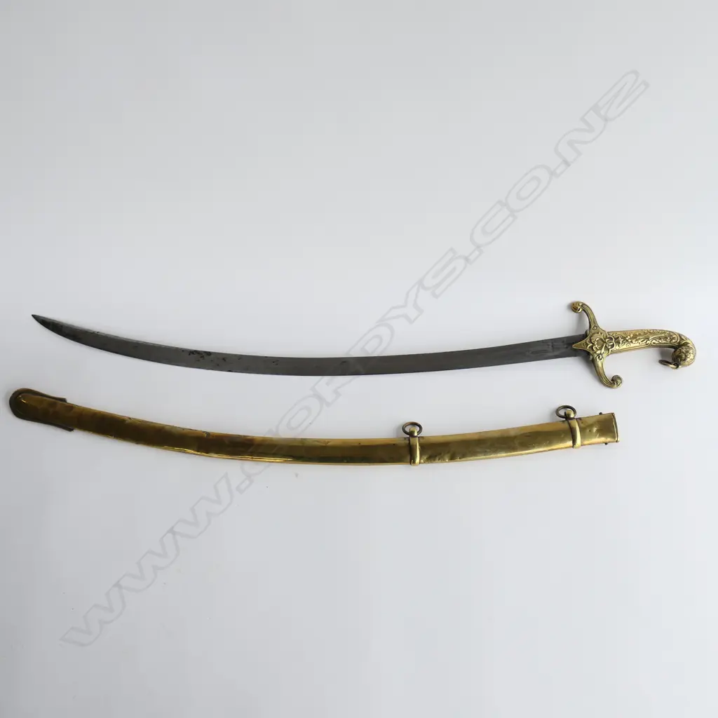 British Mamaluke-stle Army Band sword, with cast brass grip, recurved crossguard with langets, pommel with foliate raised decoration, and ring for sword knot. 710mm curved, single edged blade with scattered light to moderate pitting. Image 1++