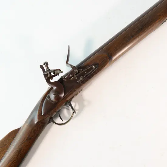 Reproduction copy of a Brown Bess flintlock, .75 cal rifle. 39" barrel. No maker’s marks or stamps to action or barrel,