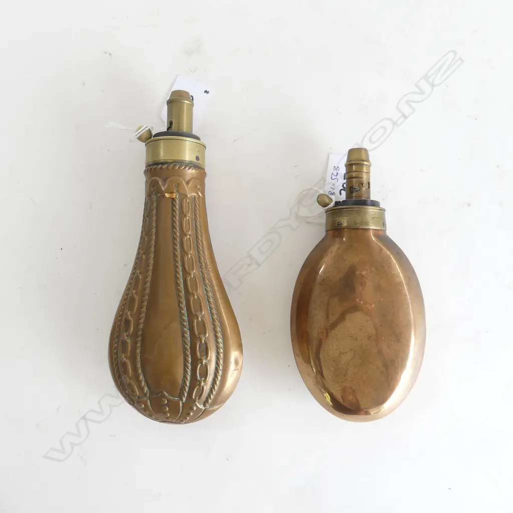 Two copper gunpowder flasks; one bag shaped marked ‘Dixon & Sons’ on the graduated nozzle the body with chain link moulding; the other plain and unmarked. Image 1++