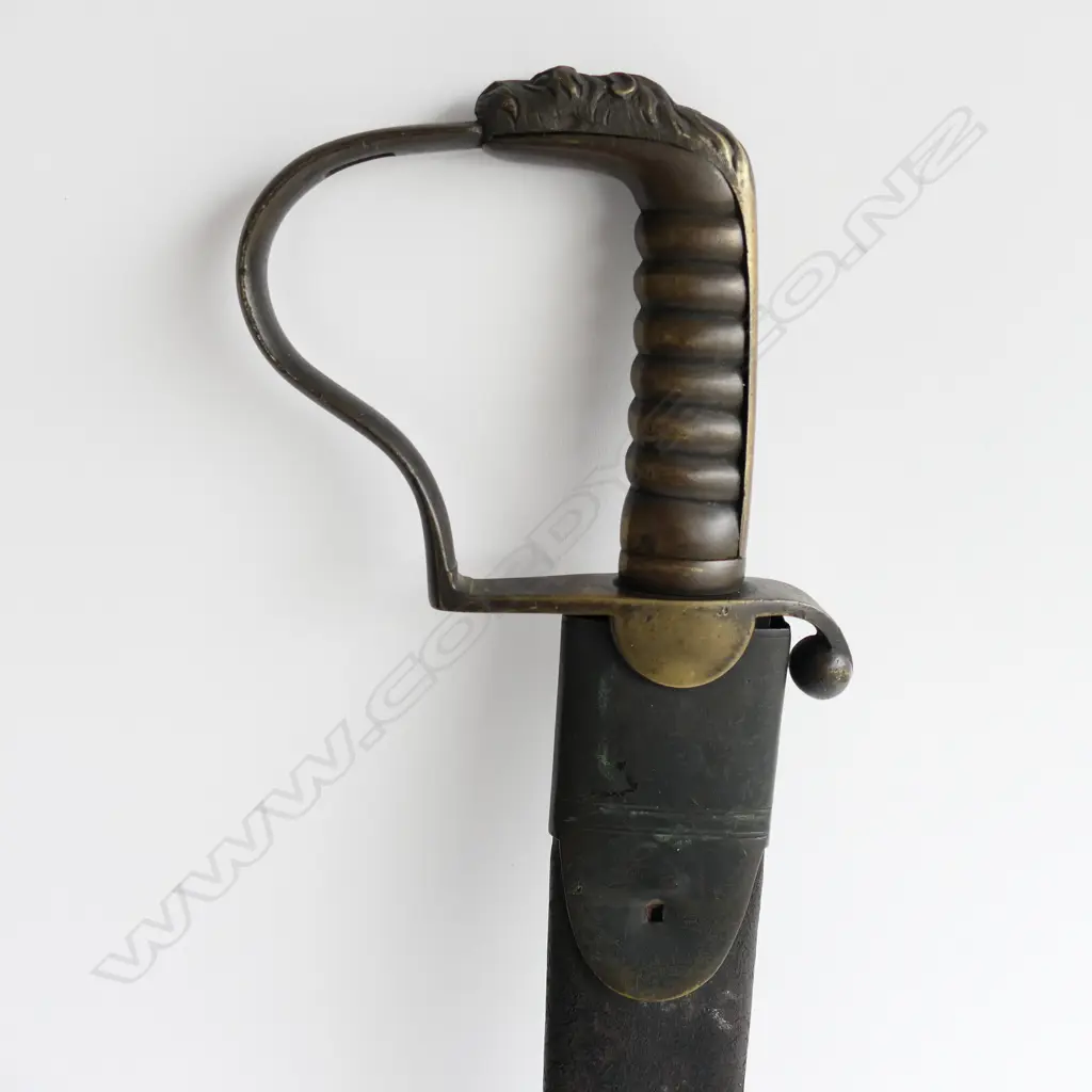 A c.1830 Pioneer Rifleman's sawback hanger, with spear point 600mm blade, brass P-guard hilt with lion's head pommel. Leather scabbard (nearly cracked through) with brass fittings Image 1++