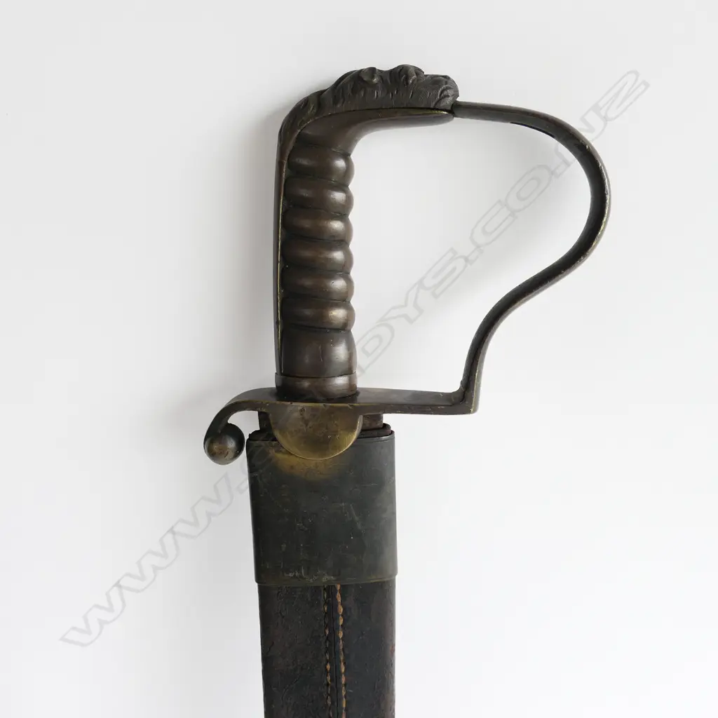 A c.1830 Pioneer Rifleman's sawback hanger, with spear point 600mm blade, brass P-guard hilt with lion's head pommel. Leather scabbard (nearly cracked through) with brass fittings Image 1++