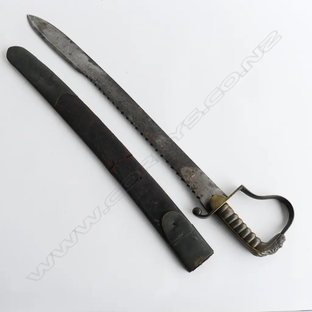 A c.1830 Pioneer Rifleman's sawback hanger, with spear point 600mm blade, brass P-guard hilt with lion's head pommel. Leather scabbard (nearly cracked through) with brass fittings Image 1++