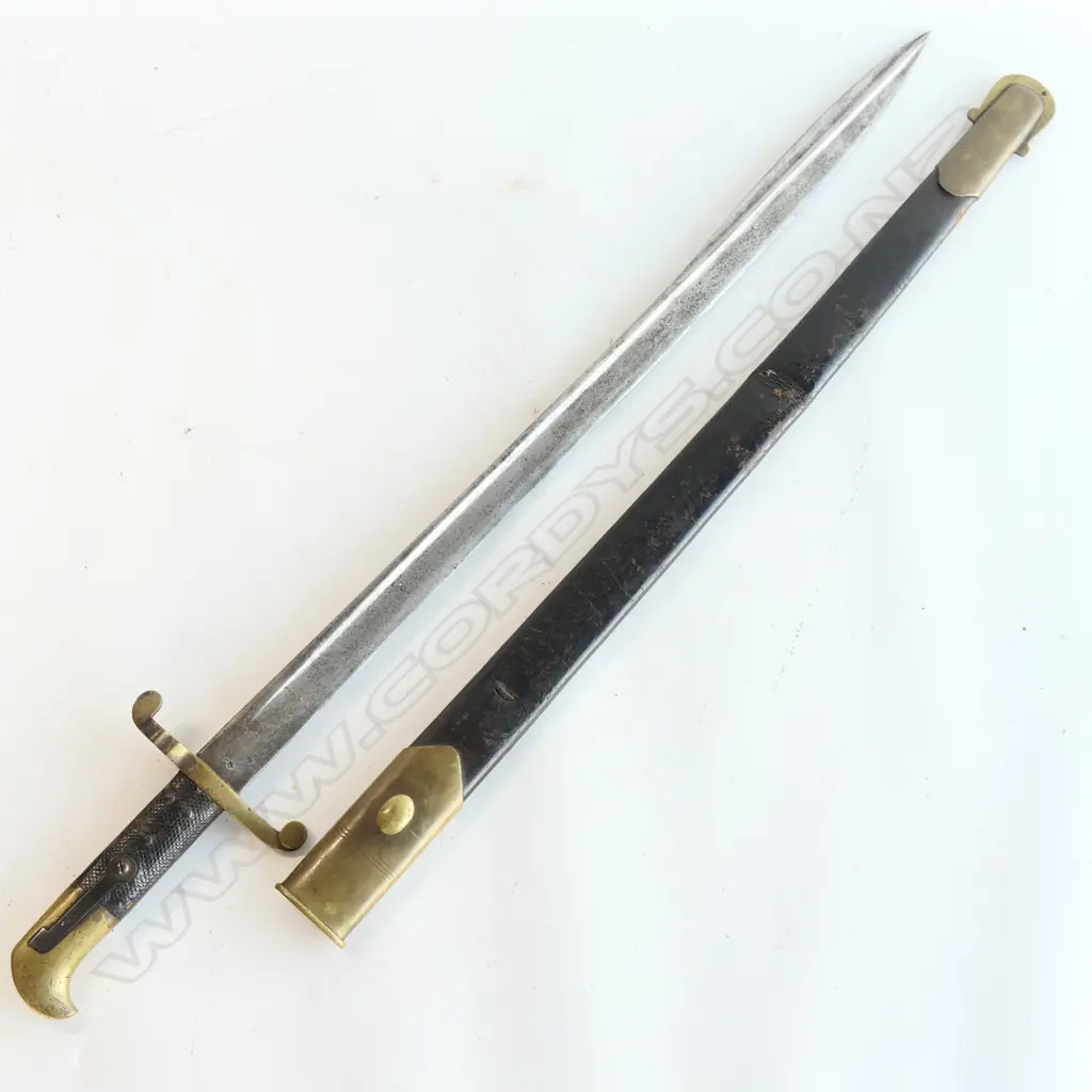 Lancaster Pattern 1855 bayonet with leather scabbard. Made for the Lancaster Carbine Rifle, pipe back spear pointed blade with even stained patina, leather grips and brass hilt, and crossguard numbered 108, brass mounted black leather scabbard with one crease. Image 1++