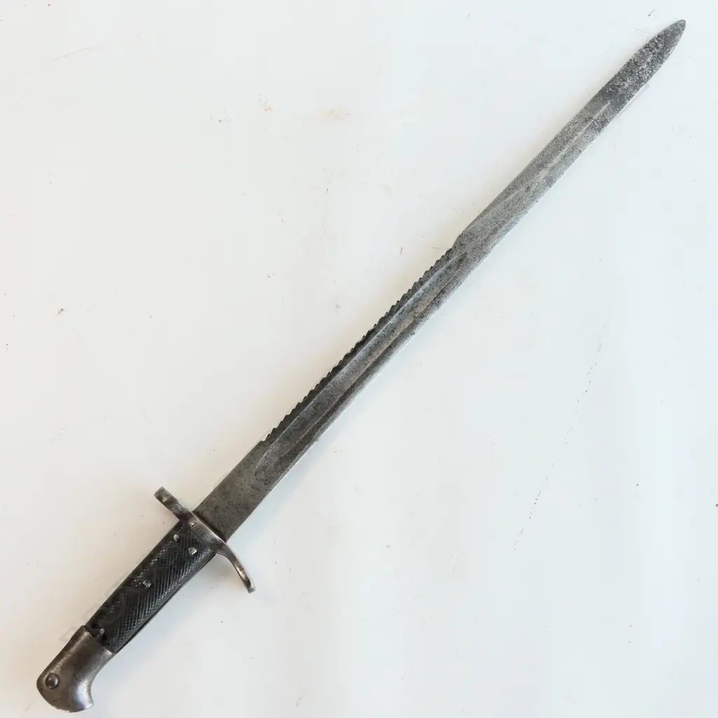 A Snider saw back sword bayonet, with leather grips. Pitted cross guard. Numbered 779. 510mm long saw back blade. Conversion date of 9 81. Some pitting at blade end. No scabbard. Image 1++