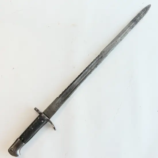 A Snider saw back sword bayonet, with leather grips. Pitted cross guard. Numbered 779. 510mm long saw back blade. Conversion date of 9 81. Some pitting at blade end. No scabbard.