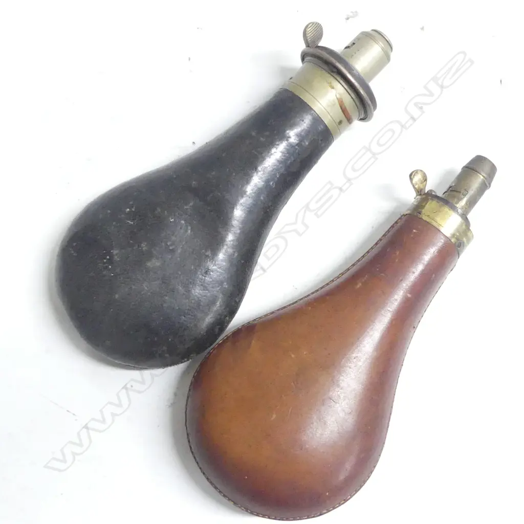 Two leather bag shaped powder flasks one black the other brown Image 1++
