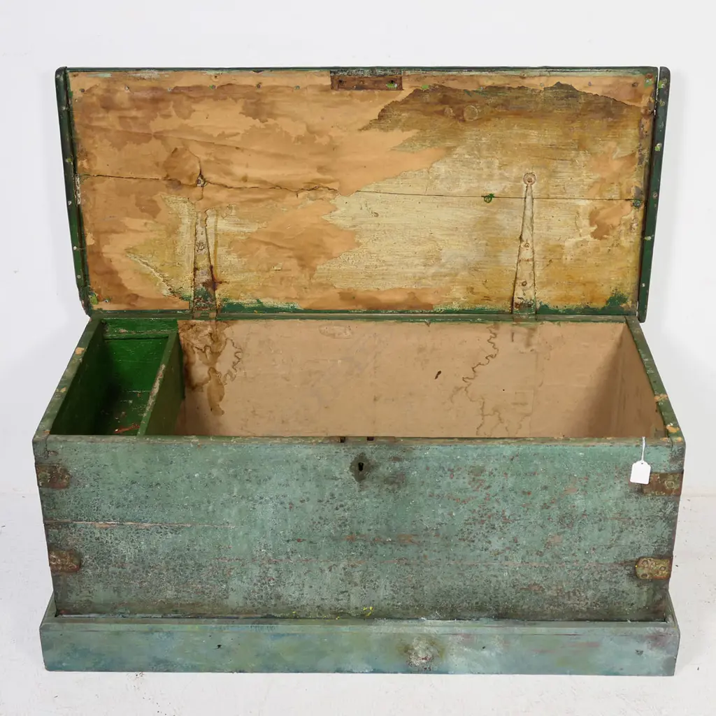 A 19thC green painted footlocker, with rope carry handles and iron strapped dovetailed corners, plinth base, hinged lid, candle box to interior, mortice lock with tongue absent. 950 x 420 x 430mm Image 1++