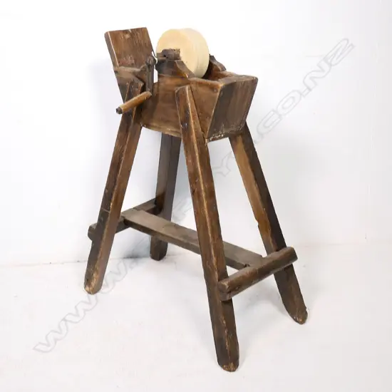 A 19thC blade sharpening grindstone wheel supported on a fruitwood trough frame, raised on four legs with a stretcher base.  720 x 380 x 900mm