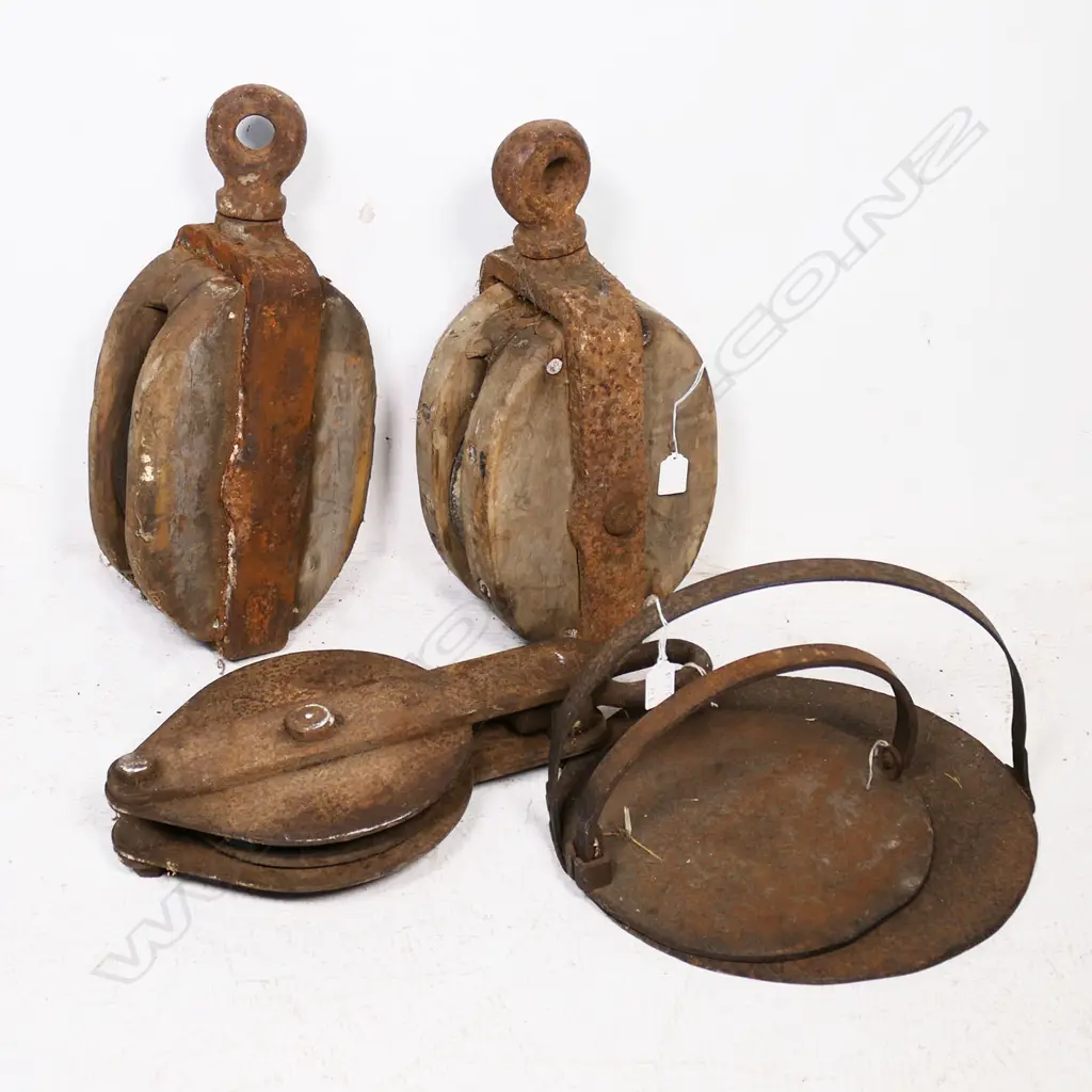 Two cast iron Griddles and three large old pulleys, one wood, one iron. Image 1++