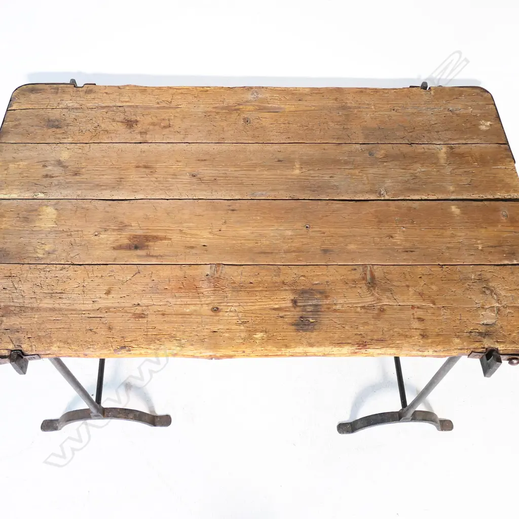 A mid-19thC wrought iron and pine military campaign table, the plank top with iron strapped corners, raised on two stirrup based wrought iron legs. 1230 x 7870 x 770mm Image 1++