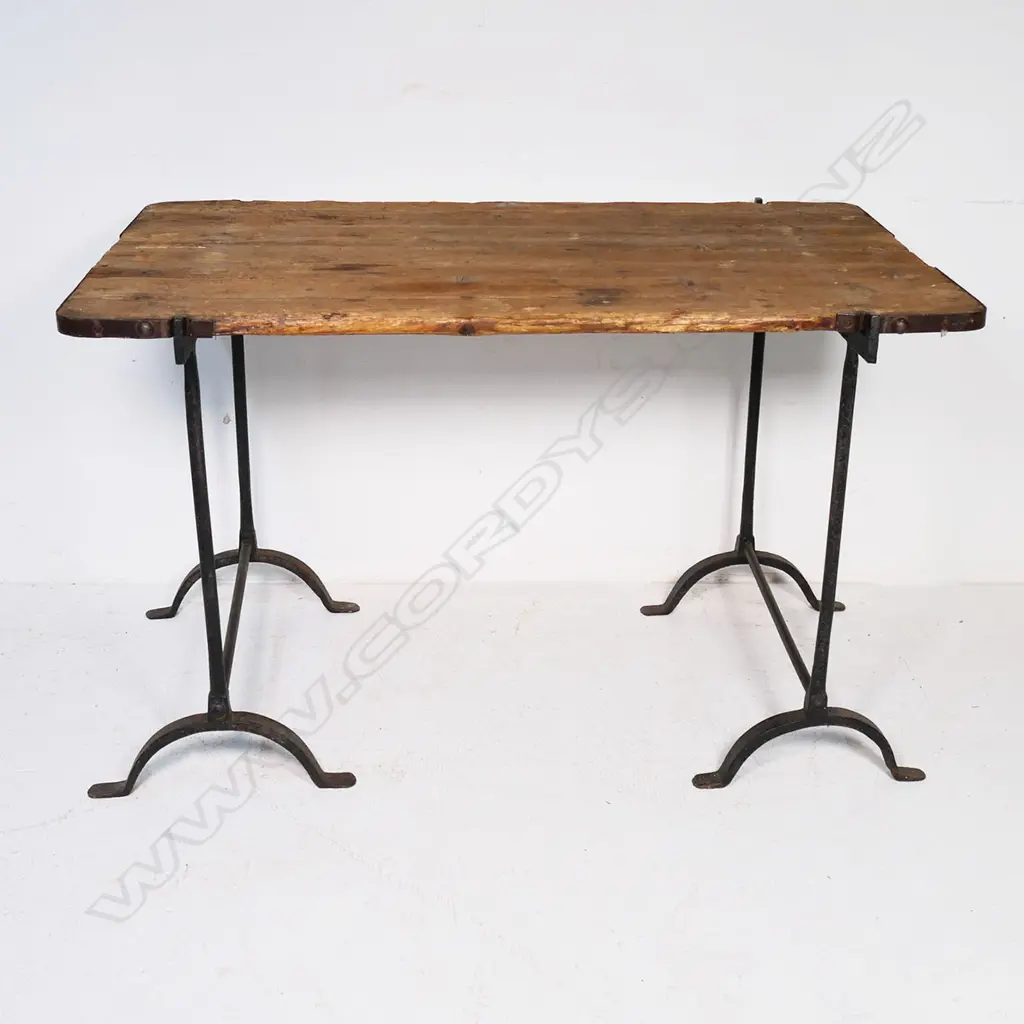 A mid-19thC wrought iron and pine military campaign table, the plank top with iron strapped corners, raised on two stirrup based wrought iron legs. 1230 x 7870 x 770mm Image 1++