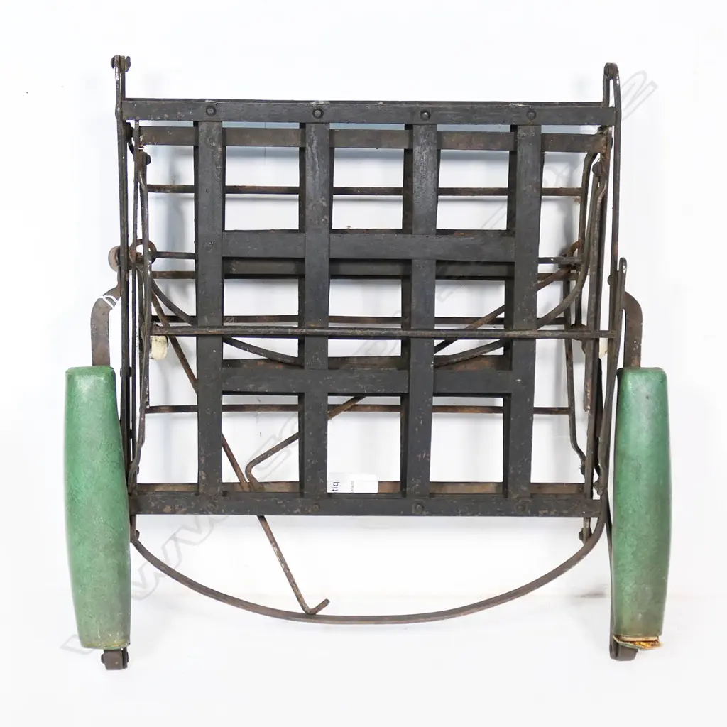 A wrought iron folding chair, on porcelain castors and later green padded arm rests Image 1++