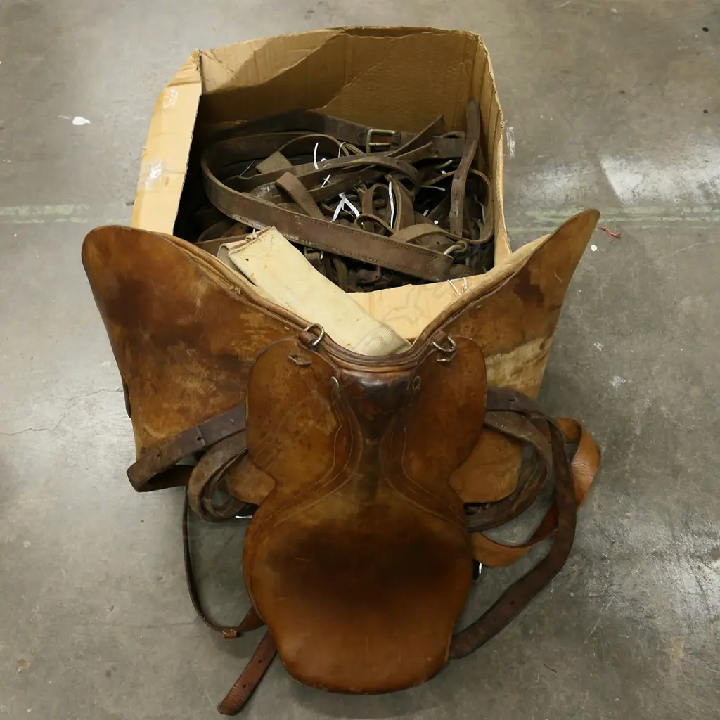 * A leather saddle along with a box of various straps Image 1++