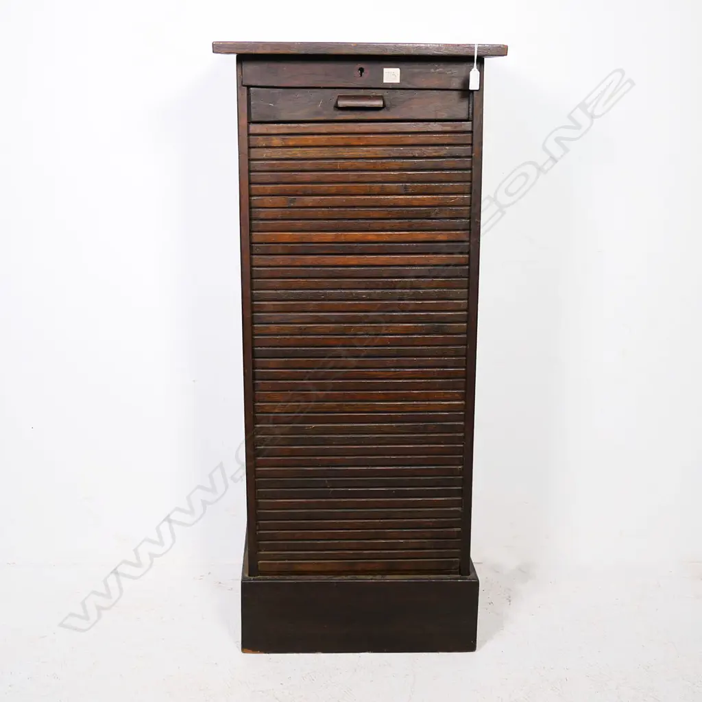 A tall oak office cabinet, with vertical tambour roll door. Locked and without key. Image 1++