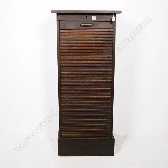 A tall oak office cabinet, with vertical tambour roll door. Locked and without key.