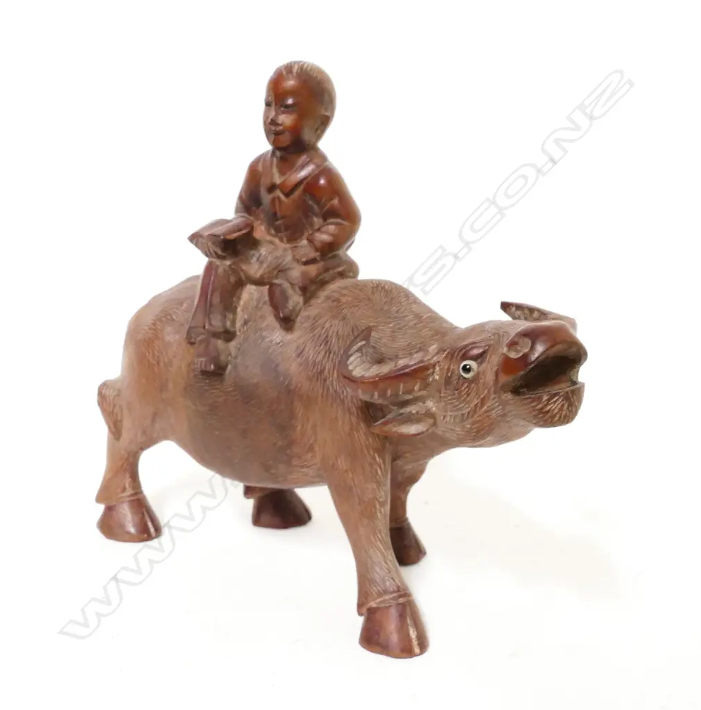 A carved rosewood figure depicting a boy riding a bullock Image 1++