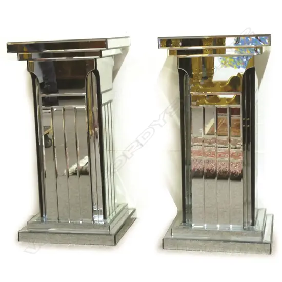 A pair of highly decorative mirrored column stands of square section