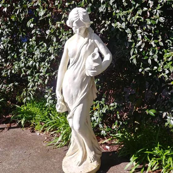 A white painted concrete garden ornament of Aquarius