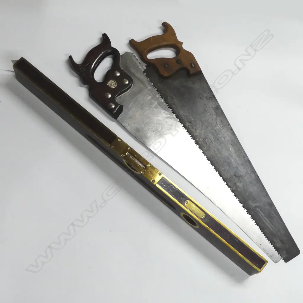 Two various panel saws and a Stanley Rule & Level Co brass and mahogany level, (Patented 1898 and earlier), in green canvas bag Image 1++