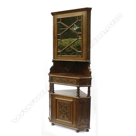 A carved oak corner cupboard