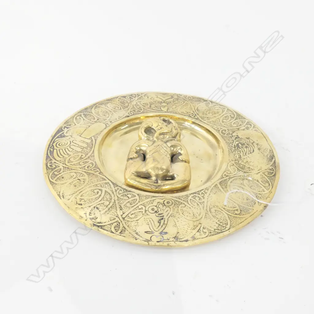 A BRASS PLATE WITH APPLIED HEI TIKI AND MAORI MOTIF BORDER D 240 MM  Image 1++