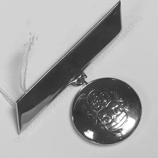 BROOCH WITH DOUBLED SIDED DROP SHOWING MAORI TIKI AND ON REVERSE A SAILING SHIP