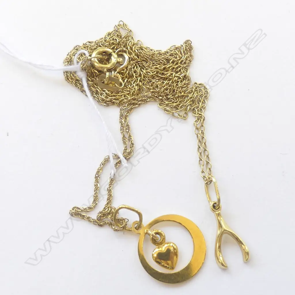 TWO 14CT YELLOW GOLD PENDANTS ON CHAINS. A wishbone and a heart in a circle. One chain is 14ct Image 1++