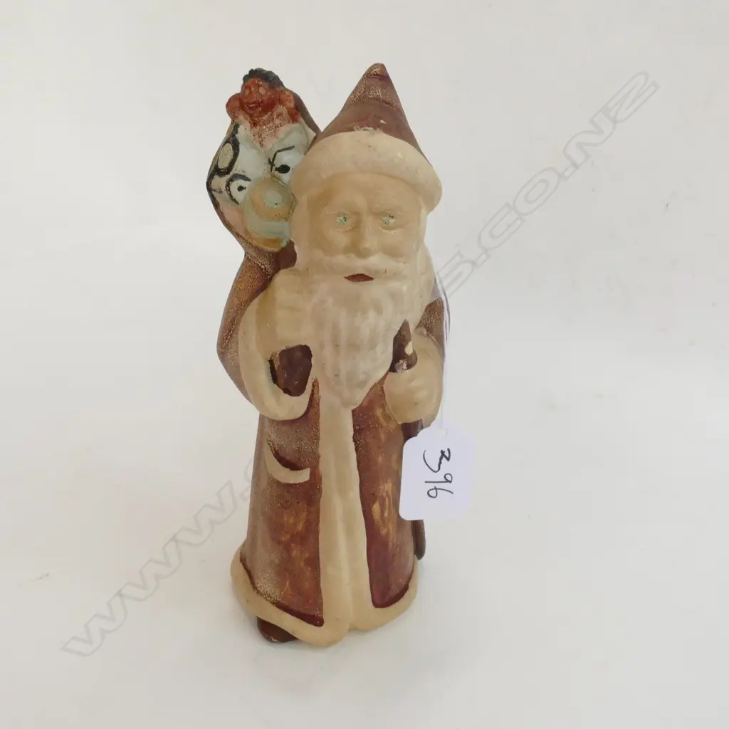 An old spartan figure of Santa Clause wearing red coat and hat with staff and sack of presents Image 1++