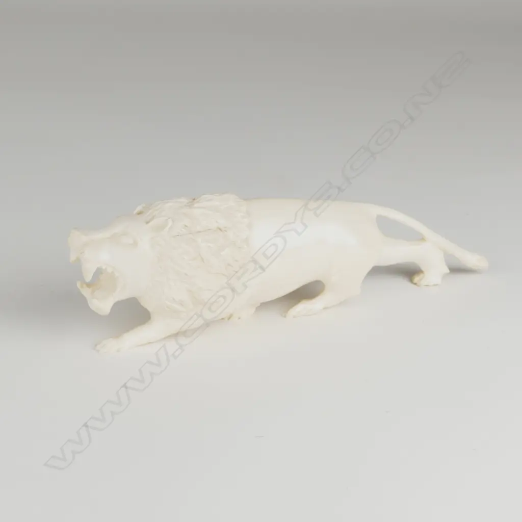 A solid ivory figure of a ferocious stalking lion Image 1++