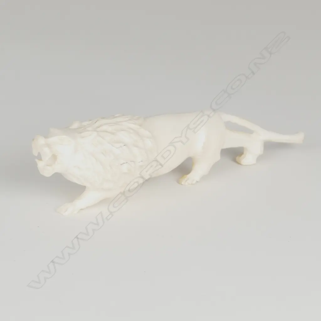 A solid ivory figure of a ferocious stalking lion Image 1++