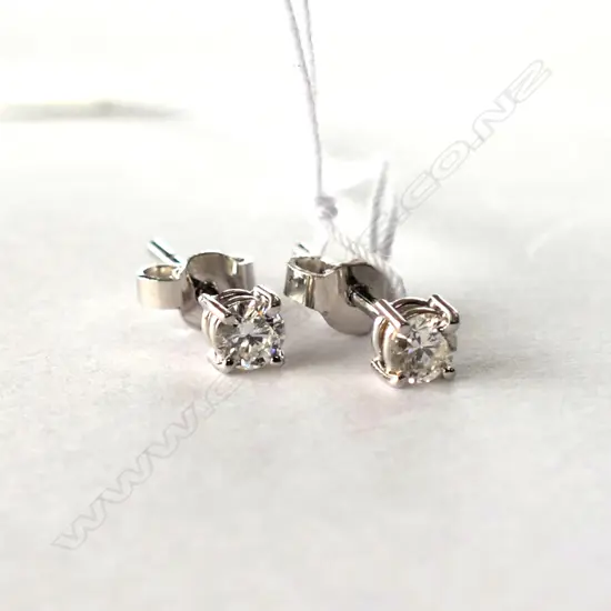 Each earring set with 0.18ct round brilliant cut diamond