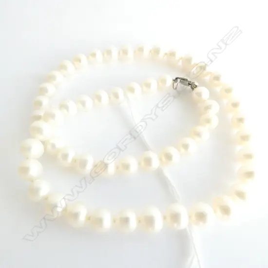 A STRING OF LUSTER PEARLS WITH STERLING SILVER CLASP