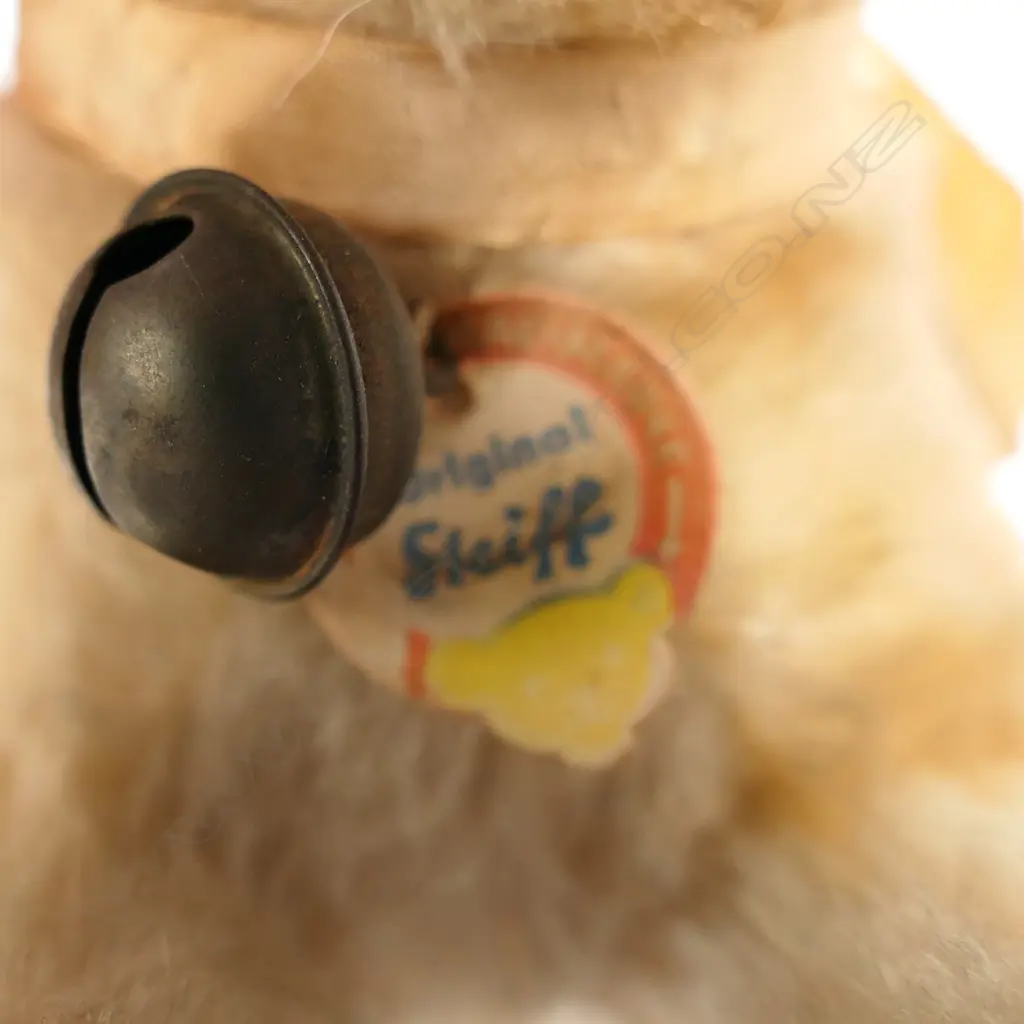 1314. With light tan wool plush; brown and black plastic eyes; red painted wooden wheels; button and tag in ear and paper label to bell. Image 1++