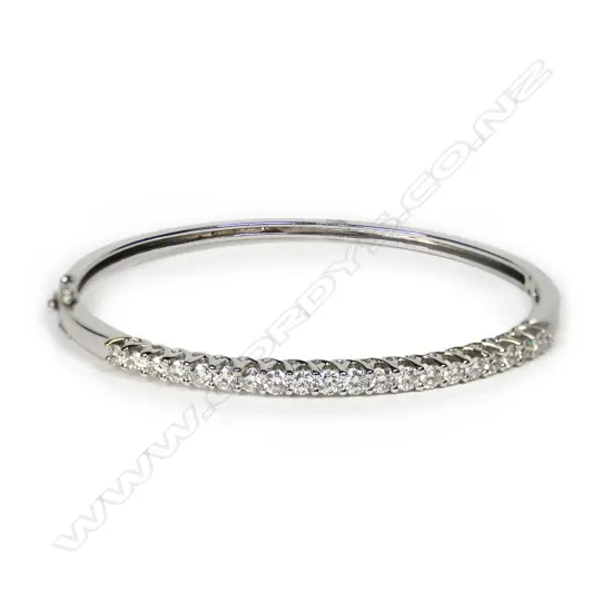 An 18ct white gold and diamond set half hinged bangle, the top with 21 round brilliant cut diamonds of TDW. 2.07ct secured in curved cross-over design settings. Graded H-I and SI-I1. 11.90gms. Valuation available.