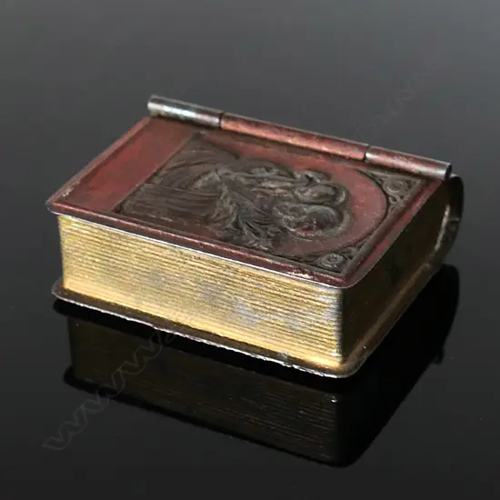 Small Metal Box in the shape of a book, hinged front cover embossed with image of an icon of St Joseph holding the child Jesus
