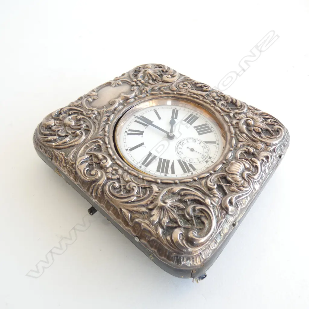 The large watch with Roman numerals to the white enamel dial. Apparently working. The embossed silver cover hallmarked Birmingham 1903 with strut back. 115 x 105mm Image 1++