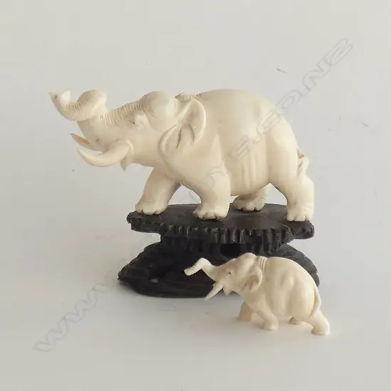 2 CARVED IVORY ELEPHANTS; 1 ON WOODEN STAND (L 105MM) & ONE L 50MM